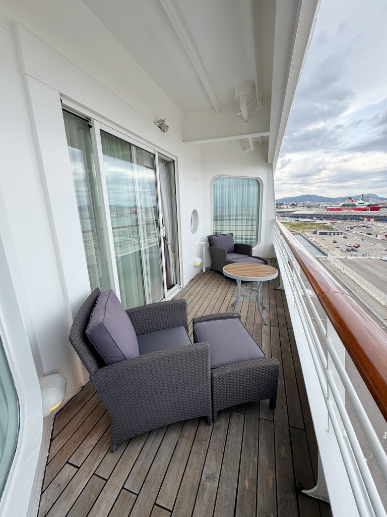 A spacious Veranda with two reclining chairs and a table.