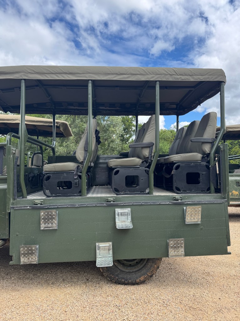 The side view of a safari jeep, with the door folded down and steps to use to climb into the jeep.
