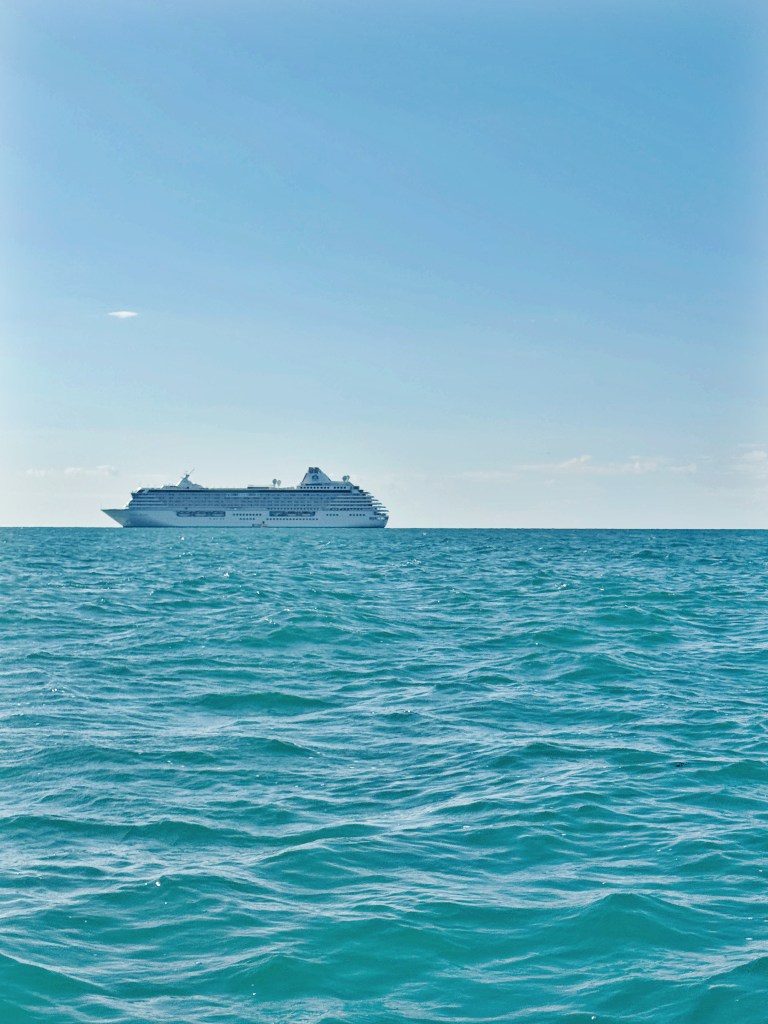 Crystal Serenity at anchor in the Ocean. A very blue sky and ocean
