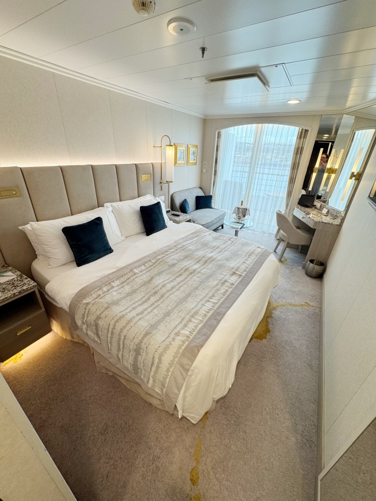 A large bed in the foreground and the veranda door in the background.