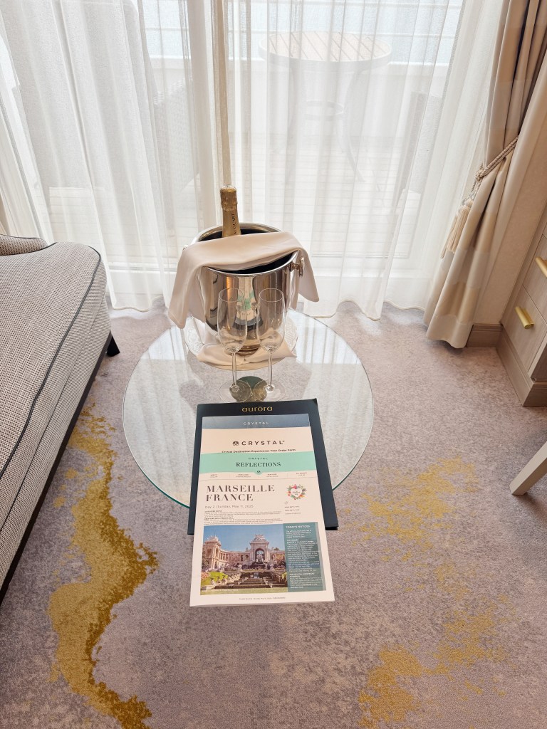 A glass coffee table with a bucket of ice and Champagne bottle on it.
