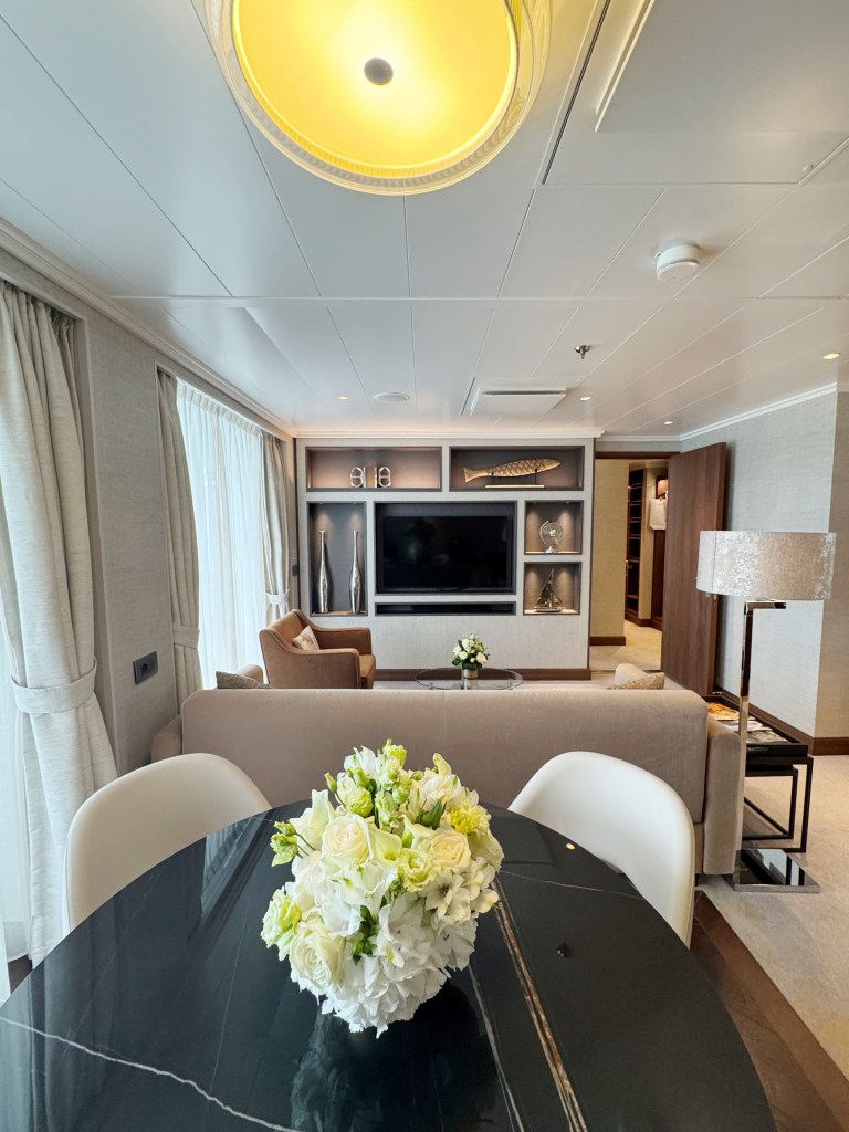 A dining table in the foreground with a lounge area in the back ground.