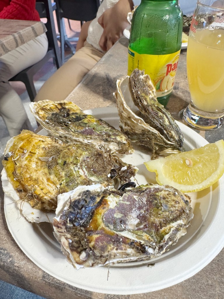 multiple Oysters in their shells on a plate on a table.