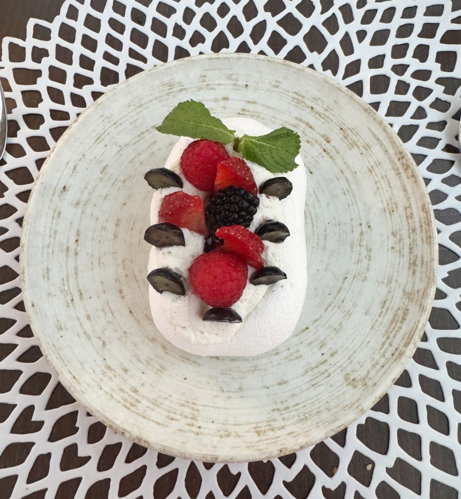 A Dessert, a Pavlova with berries on top.