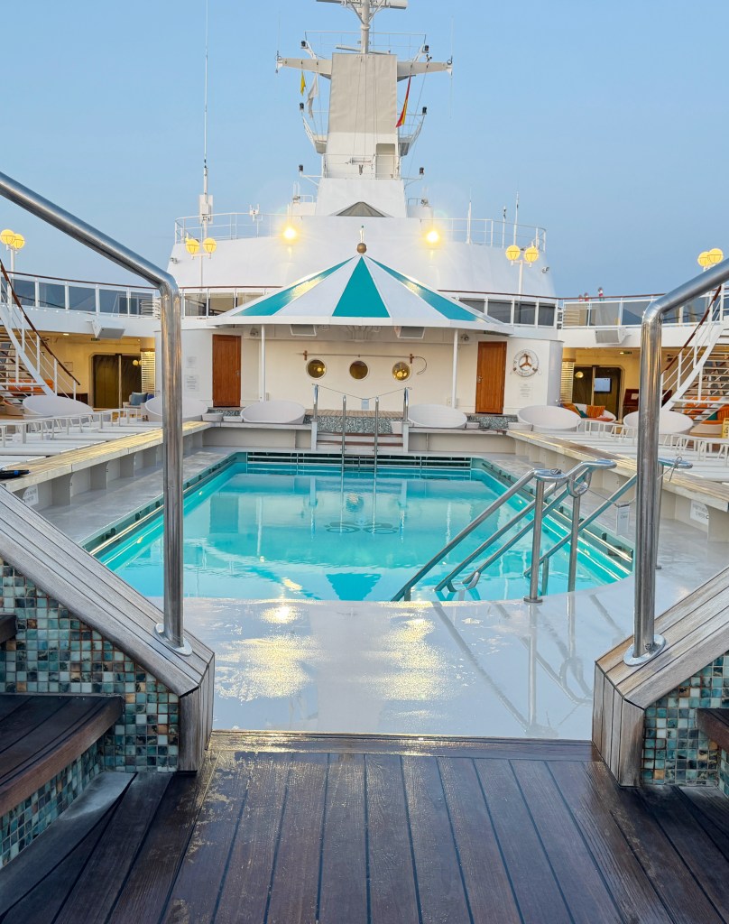 A view of a deck swimming pool on a crystal serenity looking lengthways down the pool.