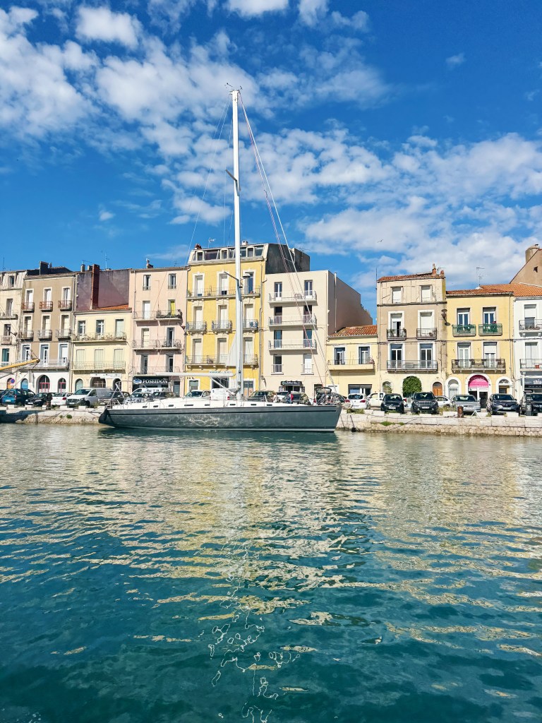 A yacht along side a quayside of Mediterranean buildings in Sete France