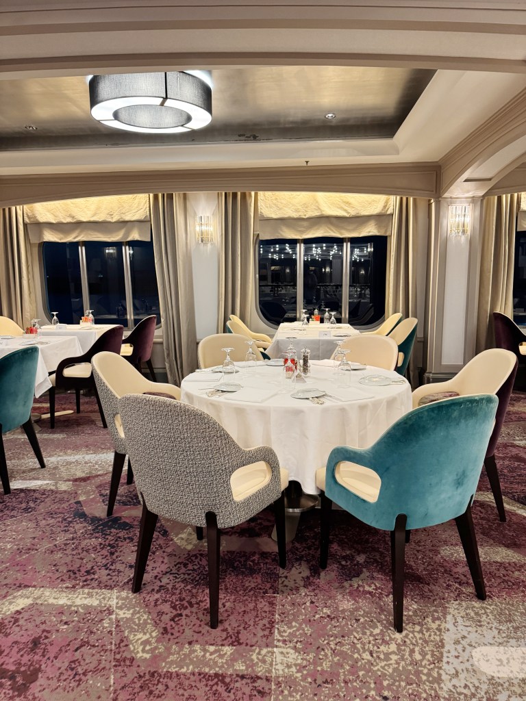 A dining table set in the Waterside Restaurant, close to windows.
