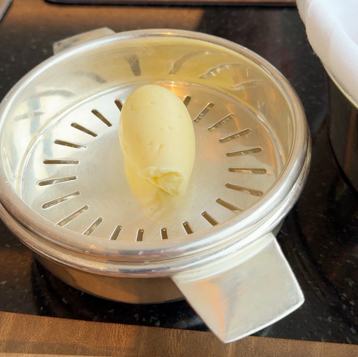 A piece of butter on a silver dish